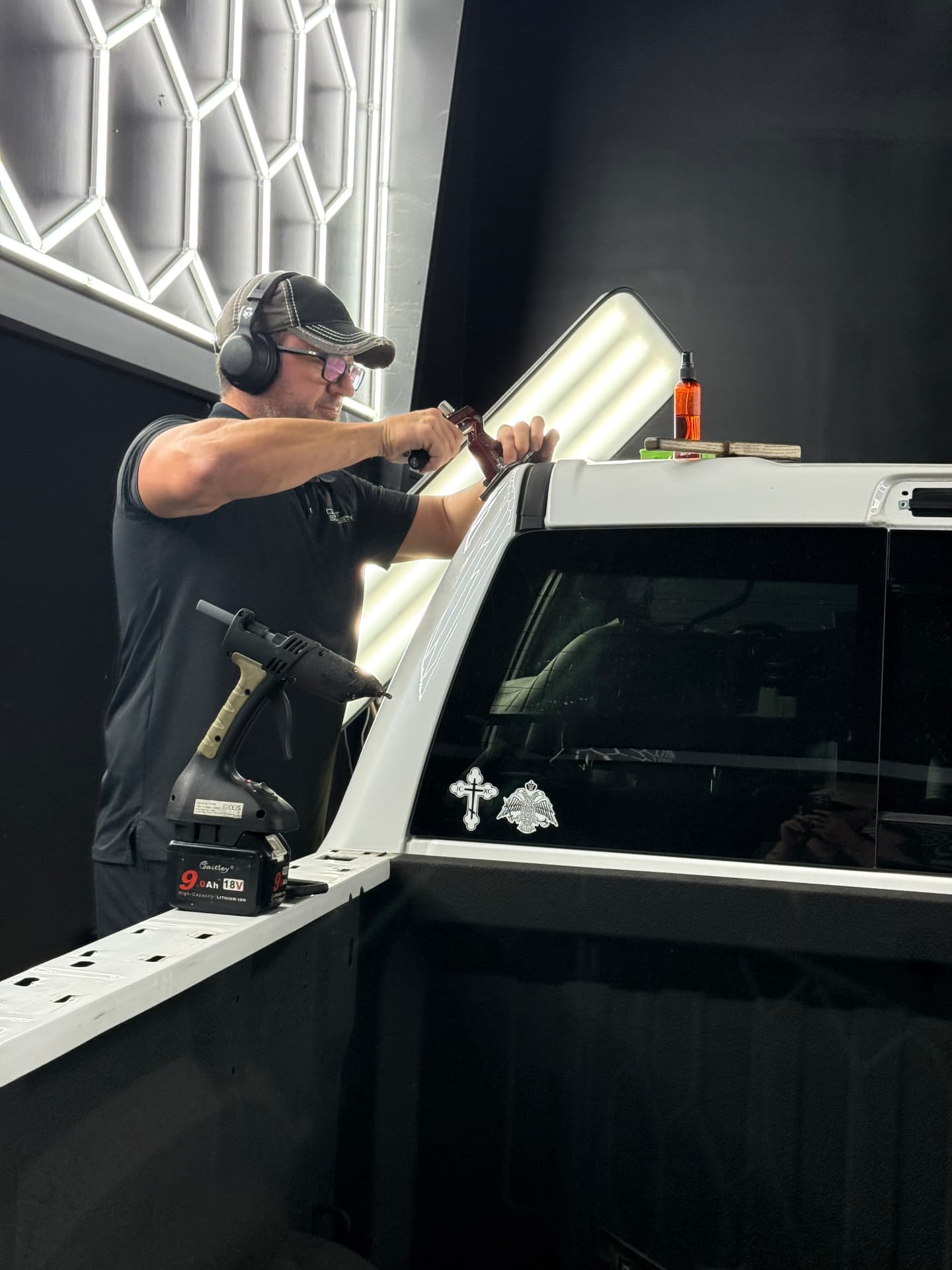 PDR technician performing paintless dent repair on a pickup truck