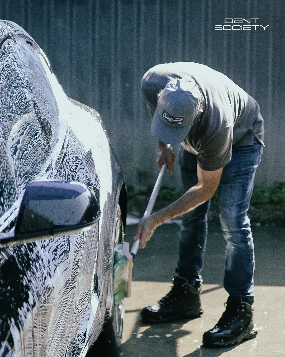 Dent Society technician hand washing a vehicle during detailing